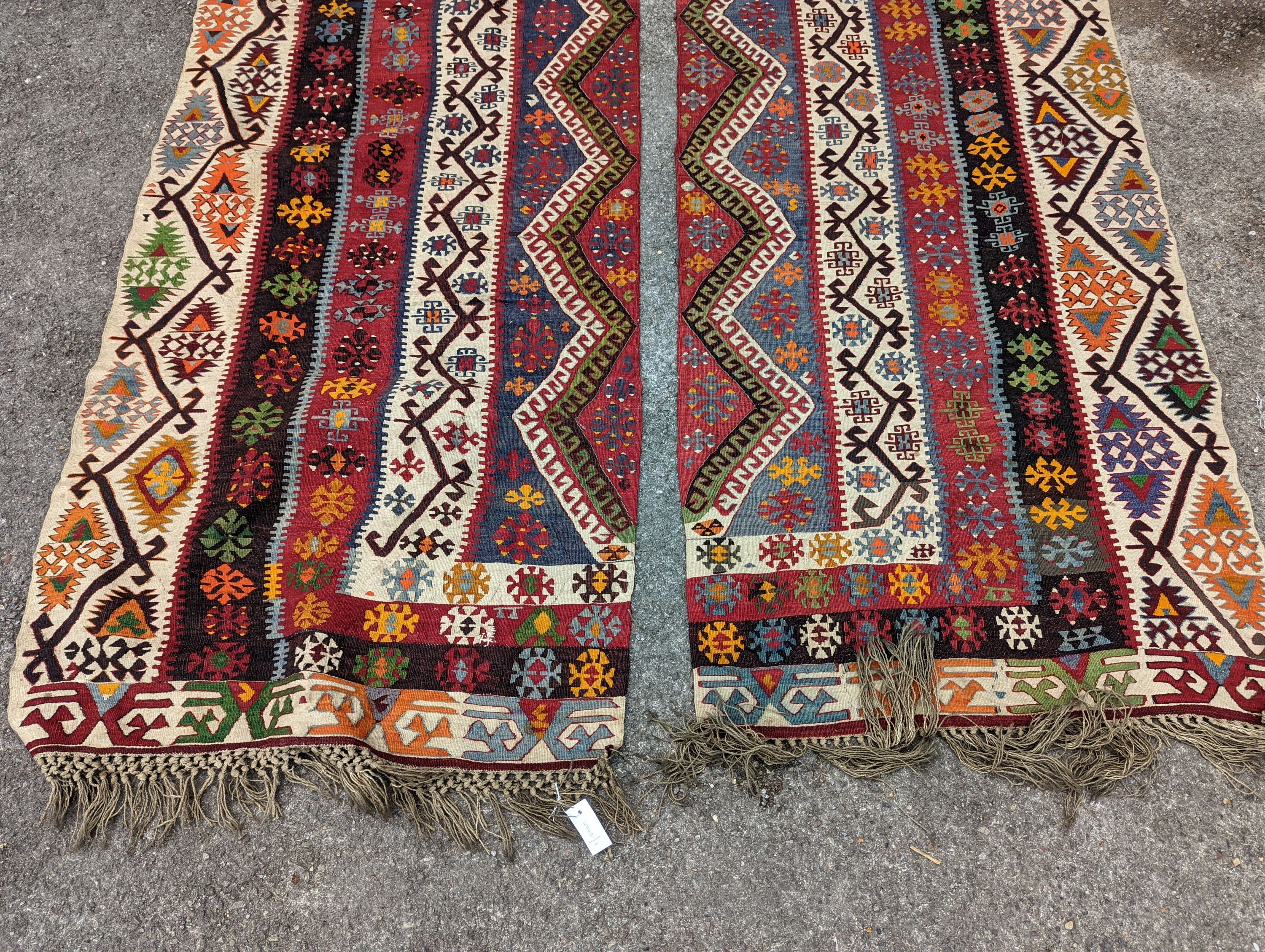 A Kilim polychrome flatweave carpet, cut centrally to create a pair of runners, each 440 x 97cm